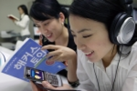 KTF 고객이 휴대폰을 이용하여 영어교육 전문 사이트인 ‘해커스’의 모바일 교육 서비스를 이용하고 있는 모습
