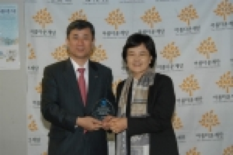 PC기증 후 아름다운 재단 윤정숙 상임이사(사진 우측)가 우리금융정보시스템 김종식 대표이사(사진 좌측)에게 감사패를 전달하고 있는 모습 