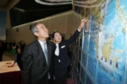 이구택 회장이 대회의장 벽면의 대형 세계지도에 부착해 놓은 임직원들의 새해 소망과 덕담을 읽고 있다.