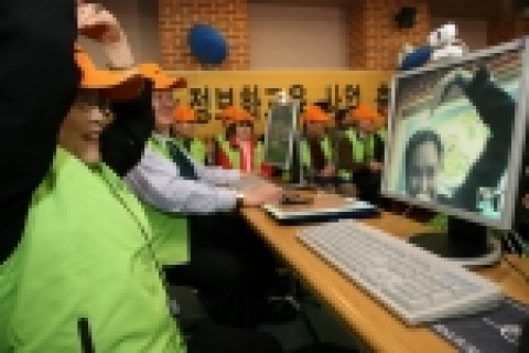 2006년 3월, <전국 경로당 정보화 교육사업 발대식>에 참가한 한 어르신이 진행자와 화상 메신저를 통해 대화하고 있는 모습
