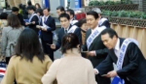 신한은행 임직원들이 지나가는 고객들에게 새해인사와 함께 상품안내장 및 기념품을 나눠드리는 모습 