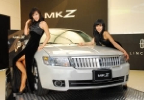 링컨 MKZ 앞에서 모델들이 포즈를 취하고 있다. 