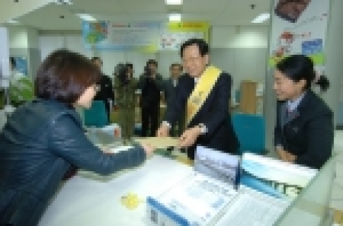 국찬표 우정사업운영위원회 위원장이 우편 창구에서 고객을 맞이하고, 우편물을 접수하며, 우편서비스 개선에 대하여 고객과 의견을 나누고 있다