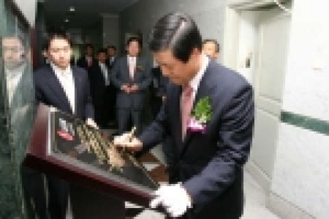 LG CNS 신재철 사장이 인니 법인 개소식 기념 사인 보드에 서명하는 모습