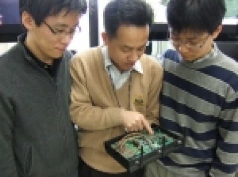 이번 연구개발의 책임자인 ETRI 이동통신연구단 차세대무선LAN연구팀 이석규 팀장(중앙)이 연구원들과 함께 무선랜 모뎀 칩을 설명하고 있다.