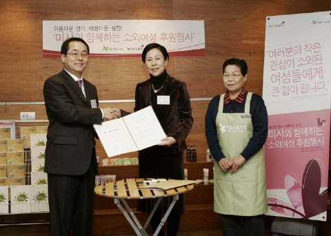 에이블씨엔씨 양순호 대표이사와 아름다운가게 손숙 공동대표가 약정서에 사인을 한 후 악수하는 모습