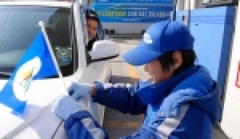 강릉지역 한 주유소에서 주유고객 차량에게 주유원이 동계올림픽 유치 기원 깃발을 부착하고 있는 모습