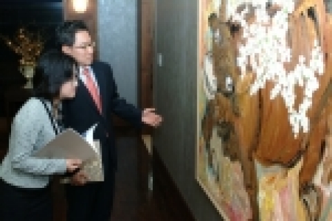 작가 사석원씨의 작품 '매화와 소'를 감상하고 있는 장면