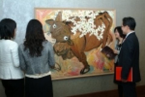 작가 사석원씨의 작품 '매화와 소'를 감상하고 있는 장면