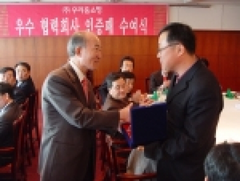 6일 양천구 목동 방송회관 건물에서 열린 ‘우리홈쇼핑 우수 협력회사 인증패 수여식’에서 우리홈쇼핑 정대종 사장(왼쪽)이 ㈜새롬어패럴 김복동 대표(오른쪽)에게 우수 협력회사 인증패를