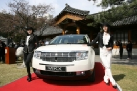 모델들이 링컨 MKX 앞에서 포즈를 취하고 있다. 