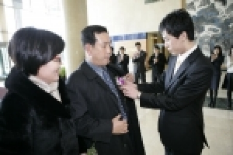 초청되신 부모님이 공사 사옥 현관을 들어오시는 순간 신입직원이 부모님 가슴에 카네이션을 달아드리는 장면