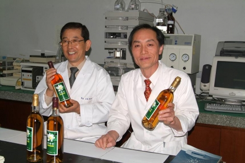 연맥주, 연와인 개발에 셩공한 동의과학대학 약재자원관리과 박진우(왼쪽)교수와 식품과학계열 조학래(오른쪽)교수. 앞은 시제품으로 제작된 연와인 제품