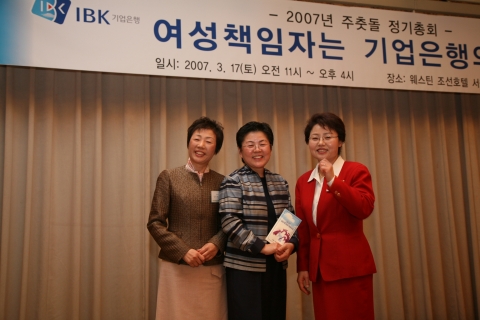 전화숙 기업은행 안암동 지행장이 강순원 (사)한국수양부모협회 회장에게 성금을 전달한 후, 포즈를 취하고 있다. 좌로부터 김길남 기업은행 인사부 조사역, 강순원 (사)한국수양부모협회
