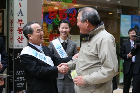 강권석 기업은행장이 명동에서 만난 고객들에게 꽃씨를 나누어주는 모습.