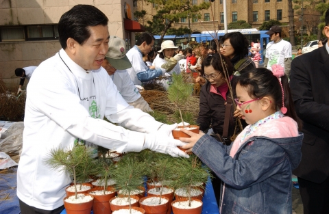 62주년 식목일을 앞두고 30일 서울 동숭동 마로니에 공원에서 개최한 ‘내 나무 갖기 캠페인’중 시민들에게 나무묘목을 나누어 주고 있는 서승진 산림청장( 사진 좌 )