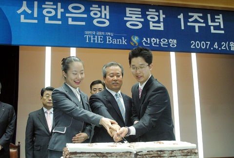 통합은행 1기 신입직원들과 기념떡을 커팅하는 신상훈 신한은행장
