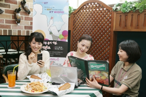 고객들이 베니건스 도곡점에서 노트북PC와 스마트폰으로 와이브로 서비스를 즐기는 모습 
