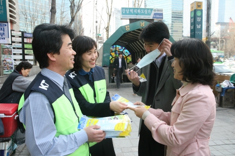 5일 아침 KT 사랑의 봉사단원들이 시민들과 재래시장 상인들에게 황사마스크를 무료로 배포하고 있다