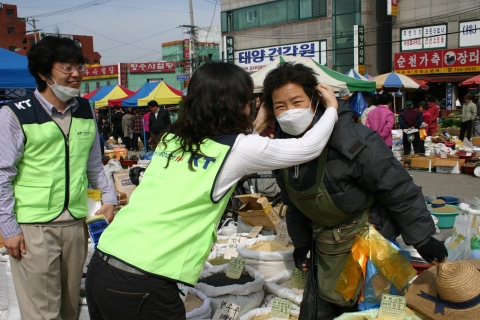 5일 아침 KT 사랑의 봉사단원들이 시민들과 재래시장 상인들에게 황사마스크를 무료로 배포하고 있다