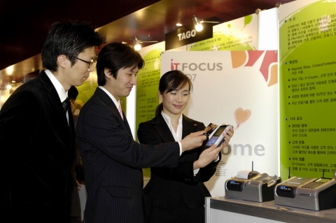 SK C&C Solution사업팀 김세영 사원이 ‘SK C&C IT FOCUS 2007’ 행사장에 마련된 부스에서 자사가 개발한 초소형의 스마트카드 복합 단말기 ‘PAYONE’를 소개하고 있는 모습