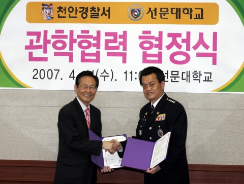 김봉태 선문대 총장과 한달우 천안경찰서장이 협약식이 끝난 후 협약서를 교환하며 악수를 하고 있다.