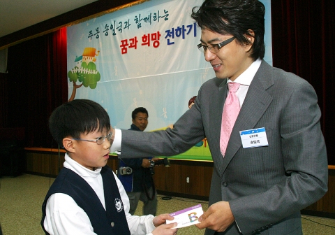 송일국씨가 소년의 집 아동에게 통장을 전달하는 모습