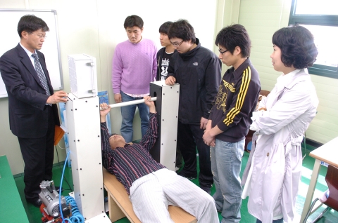 메카트로닉스공학과 학생들이 제작한 공압운동기구를 지도교수와 함께 직접 작동하고 있는 장면