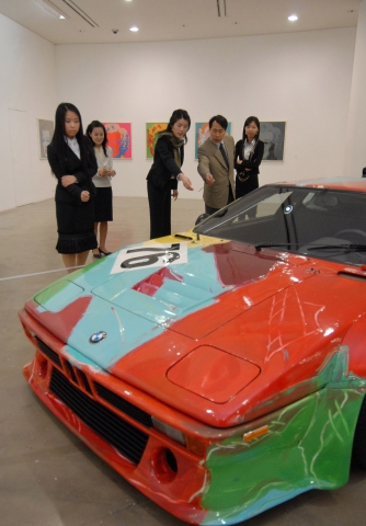 팝 아트의 거장 앤디워홀이 그린 BMW 아트카와 그의 대표작인 마릴린먼로 시리즈 작품에 매료된 관람객들의 모습.