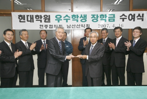 현중협의회 장학금 전달식에서 김근배 회장<오른쪽>이 현대청운고등학교 한태형 교장<왼쪽>에게 장학금을 전달하고 있다. 