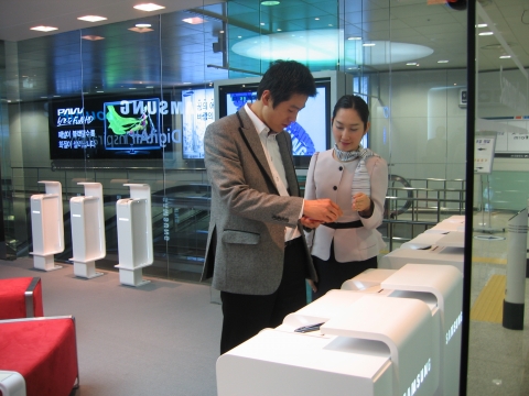 공항 이용객이 체험관내에서 핸드폰 시연하고 있는 모습