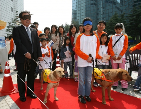 19일 오전 서울 중구 장교동 파리공원에서 열린 장애인의 날 특별행사에 참가한 (주)한화 남영선(南令鐥) 대표와 어린이가 맹인 안내견 체험을 하고 있다. 