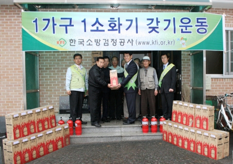 용인시 모현면 초부리 김중희 이장(左)에게 소화기를 전달하는 서광석 기획관리본부장(右)
