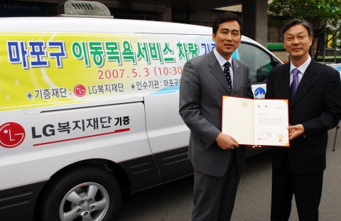 오종희 LG복지재단부사장(사진오른쪽)이 신영섭 마포구청장에게 이동목욕차량 기증서를 전달하고 있다.