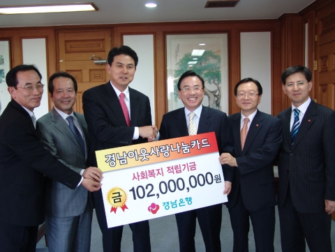 경남은행 정경득 은행장(오른쪽에서 세번째)이 김태호 경상남도지사에게 경남이웃사랑나눔카드를 통해 출연한 사회복지기금 1억2백만원을 전달하고 있다