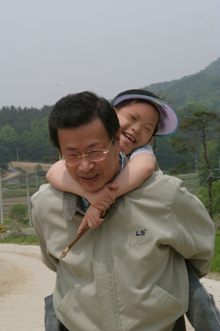 LS산전 김정만 부회장이 지체장애우를 업고 산책을 하고 있다.