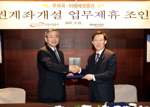 정경원 우정사업본부장(왼쪽)은 22일 오전 신라호텔에서 최현만 미래에셋증권 사장과 증권계좌 개설 업무제휴를 체결했다. 