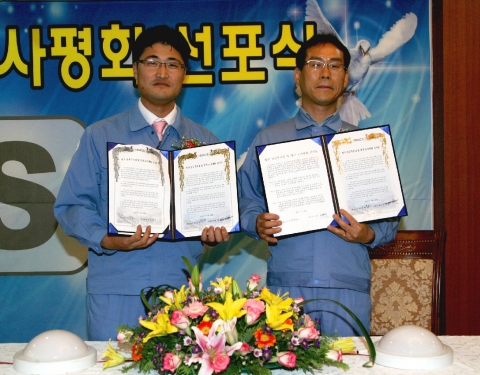 아이랙스 박승민 사장(사진 왼쪽)과 한영조 근로자 대표가 영구 노사평화 선언문에 서명한 후 노사화합을 다짐하고 있다.