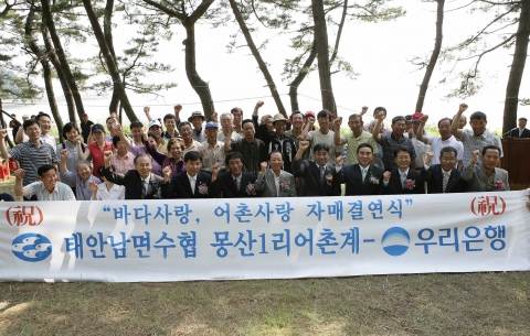 우리은행은 14일 우리은행 직원과 마을 주민 등 100여 명이 참석한 가운데 충청남도 태안군 남면 몽산1리 마을과 1사1어촌 자매 결연 행사를 가졌다.