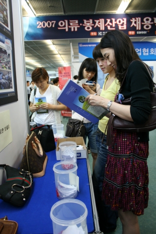 13일 대치동 섬유센터에서 열린 ‘2007 의류∙봉제산업 채용박람회’를 방문한 구직자들이 행사장에 전시된 제품 중에서 진품을 찾고 있다.
