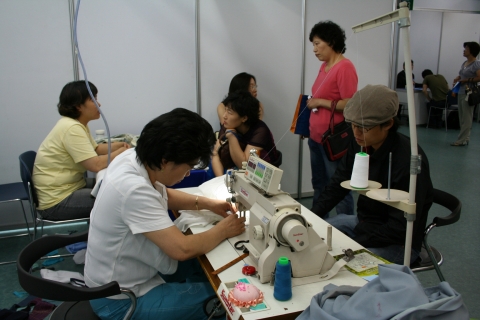 13일 대치동 섬유센터에서 열린 ‘2007 의류∙봉제산업 채용박람회’를 방문한 구직자들이 무료 리폼 서비스를 받고 있다.