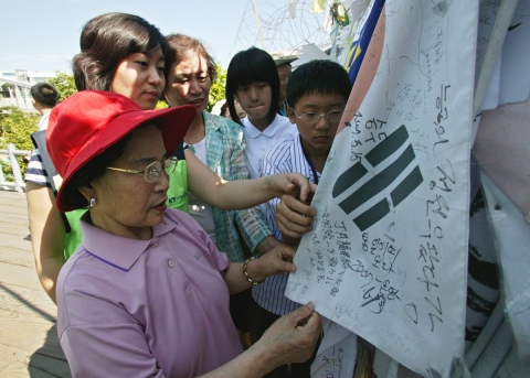 임진각 자유의 다리 앞에서 전몰 미망인들과 백석중학교 학생들, KT사랑의 봉사단원들이 함께 통일을 기원하고 있다.