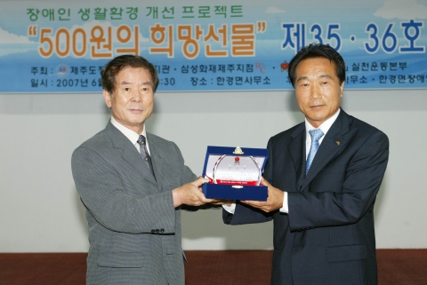 홍두표 장애인먼저실천운동본부 이사가 최수행 환경면장에게 감사패를 전달하고 있다