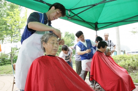 자매결연을 맺은 농촌마을 (용인시 원삼면)을 찾은 삼성전자 반도체총괄 전문봉사팀이 이발, 효도사진 촬영 등 각자 특기를 살린 전문 봉사 활동 중인 모습.