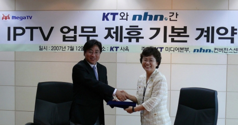 NHN 윤대균 컨버전스 센터장(좌)과 KT 이영희 미디어본부장이 계약서를 교환하고 악수를 나누고 있다. 