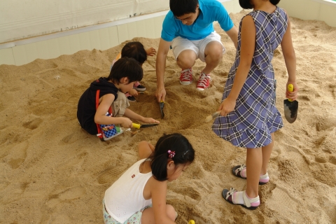 어린이들이 아빠와 함께 모레를 파헤치며 공룡화석뼈를 발굴하고 있다.