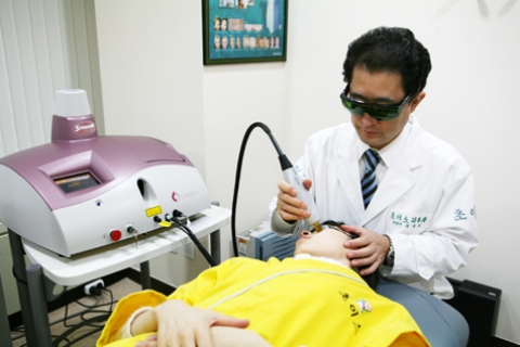 여드름 환자가 스무스빔 레이저 치료를 받고 있는 모습