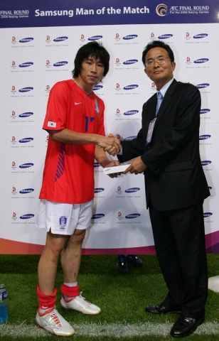 삼성전자 안홍진 상무가 삼성 맨오브더 매치(Man of the Match) 수상자인 이근호 선수에게 삼성전자 휴대폰을 시상을 하고 있다.    