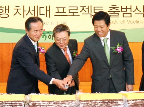 차세대 프로젝트 출범식 장면으로 시루떡을 자르고 있는 모습임.(왼쪽부터 LG CNS 심재철 사장, 김종열 하나은행장, 삼정회계법인 강성원 부회장)