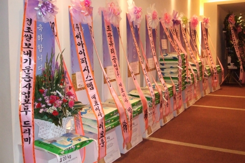 화환의 재사용을 못하게끔 쌀과 함께 꽃바구니로 된 드리미 쌀 화환